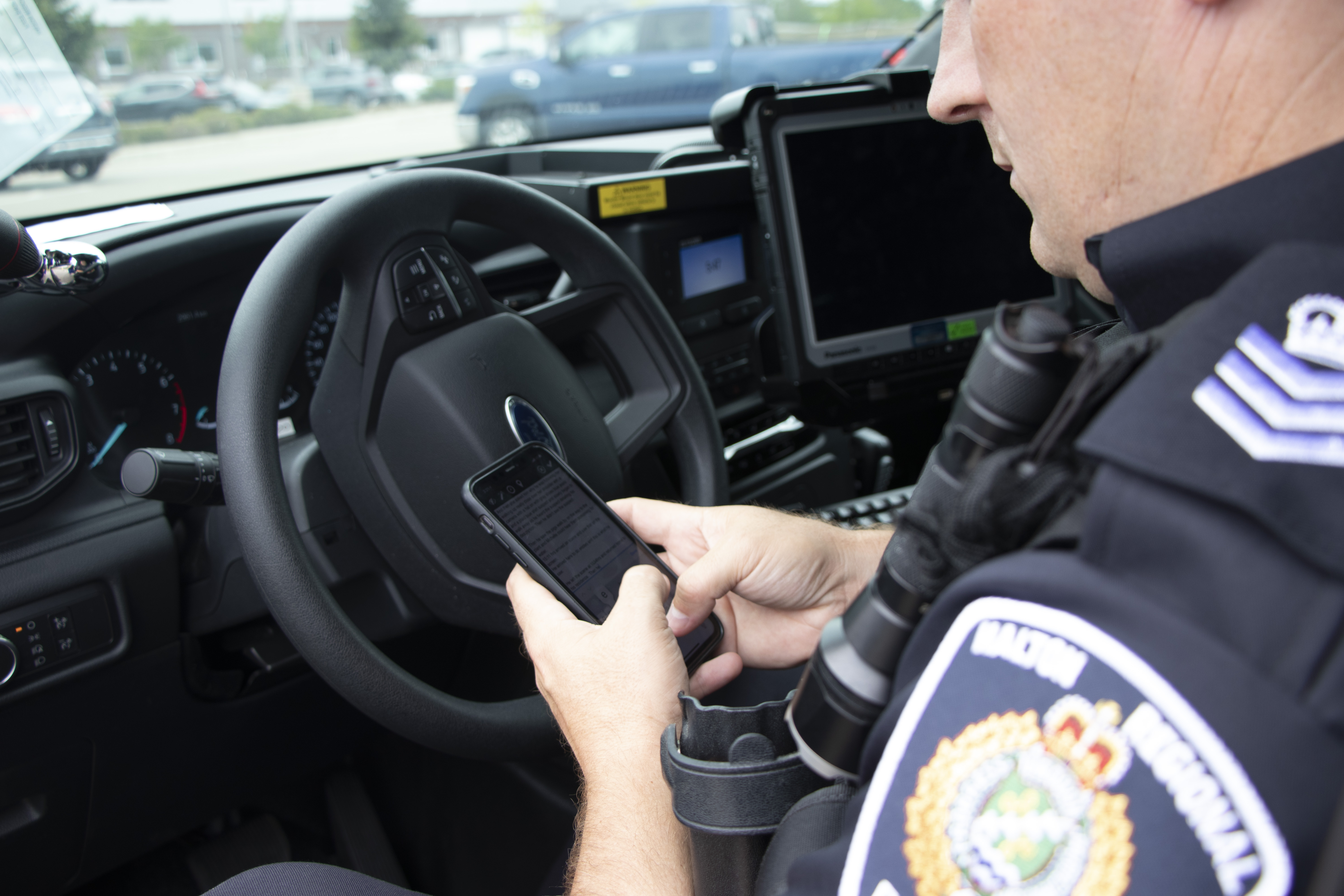 HRPS officer completing notes on his cell phone